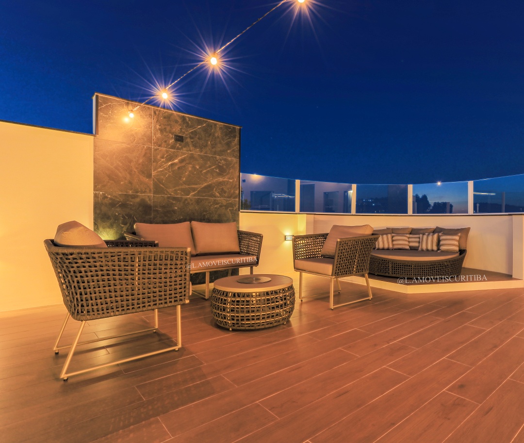 Lounge noturno com poltronas, mesa de centro e chaise redonda