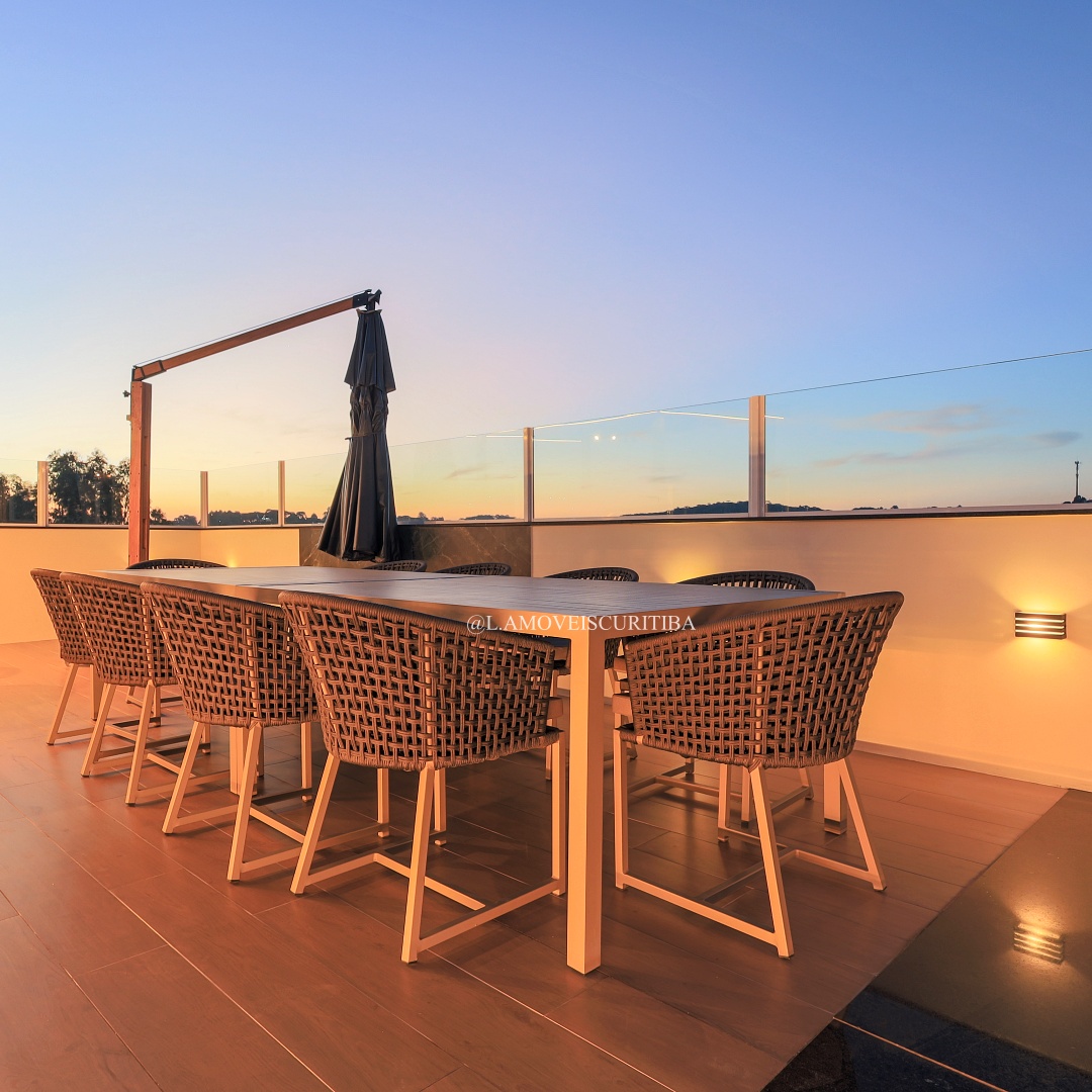 Mesa de jantar outdoor com cadeiras em fibra sintética ao pôr do sol